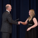 Doctor Potteiger shaking hands with an award recipient in a black dress
